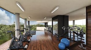 Ein Fitnessraum mit Trainingsgeräten, großen Fenstern und Blick auf Grünflächen.