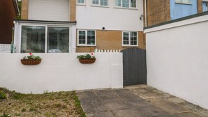 Un immeuble résidentiel doté d’un garage, d’une façade blanche et d’une partie en briques.