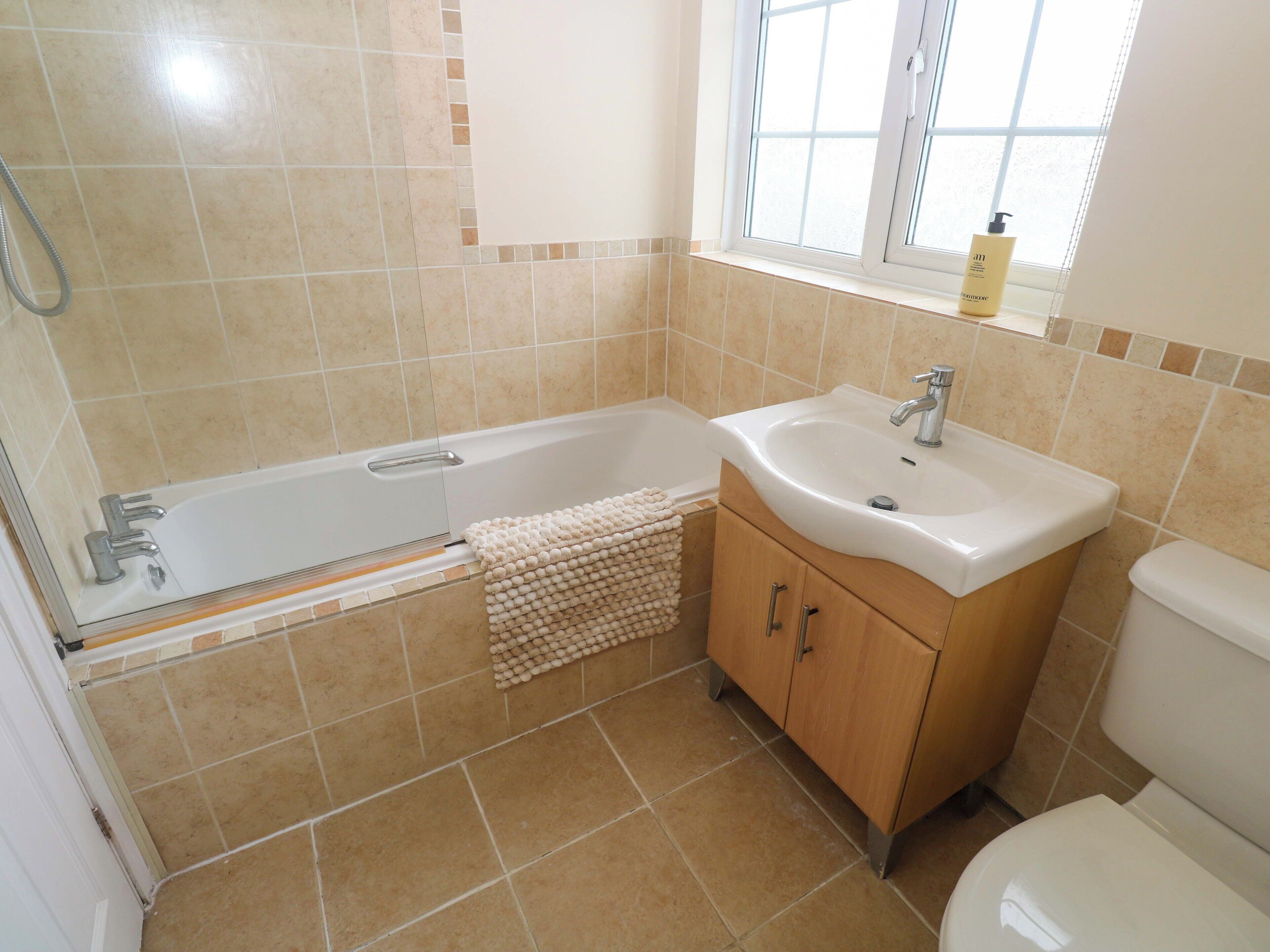 Un baño con bañera, lavamanos e inodoro.