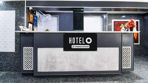 A hotel reception desk with a sign indicating it is company-serviced. - Deluxe Hotel Okasu Railway Station (Raipur)