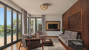 A modern living room with a sofa, chairs, a coffee table, and a TV. - Villa Nha Trang Ocean Front Luxury Abogo (Nam Nha Trang)