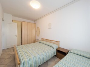 Ein Schlafzimmer mit Bett, Nachttisch, Kleiderschrank und Spiegel.