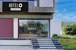 A modern hotel with a glass facade, a company-serviced sign, and a set of marble steps leading to the entrance. - Super Hotel O Mathura-bharatpur (Mathura)