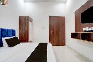 A bedroom with a bed, a wardrobe, a mirror, and a shelf. - Super Hotel O Mathura-bharatpur (Mathura)