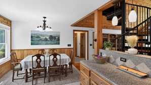 A dining area with a wooden table and chairs, a chandelier, and a painting on the wall. - Blue Ridge Retreat w/ Private Trail (Pisgah Forest)