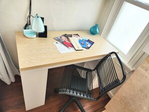 Un bureau en bois, une lampe, une chaise et des magazines.