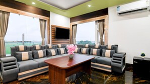 A modern living room with a sectional sofa, a wooden coffee table, and a flat-screen TV.