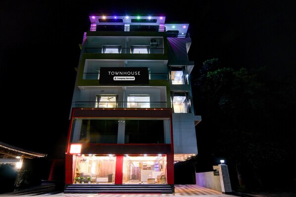 A multi-story building with a sign reading 'TOWNHOUSE' and a 'Company-Serviced' label.