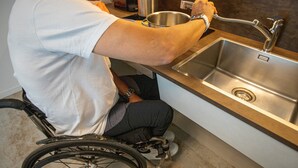 A person in a wheelchair at a modern kitchen sink with a stainless steel finish, a countertop, and a visible drain. - Chalet 'Apartment 1' with Mountain View, Shared Garden and Wi-Fi (Livigno)