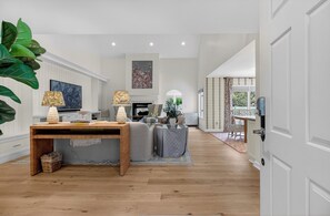 A spacious living room with a wooden coffee table, two grey sofas, a fireplace, and a large plant. - Award-Winning Resort Amenities | Fairway Oaks 8 by Wild Dunes (Isle Of Palms)