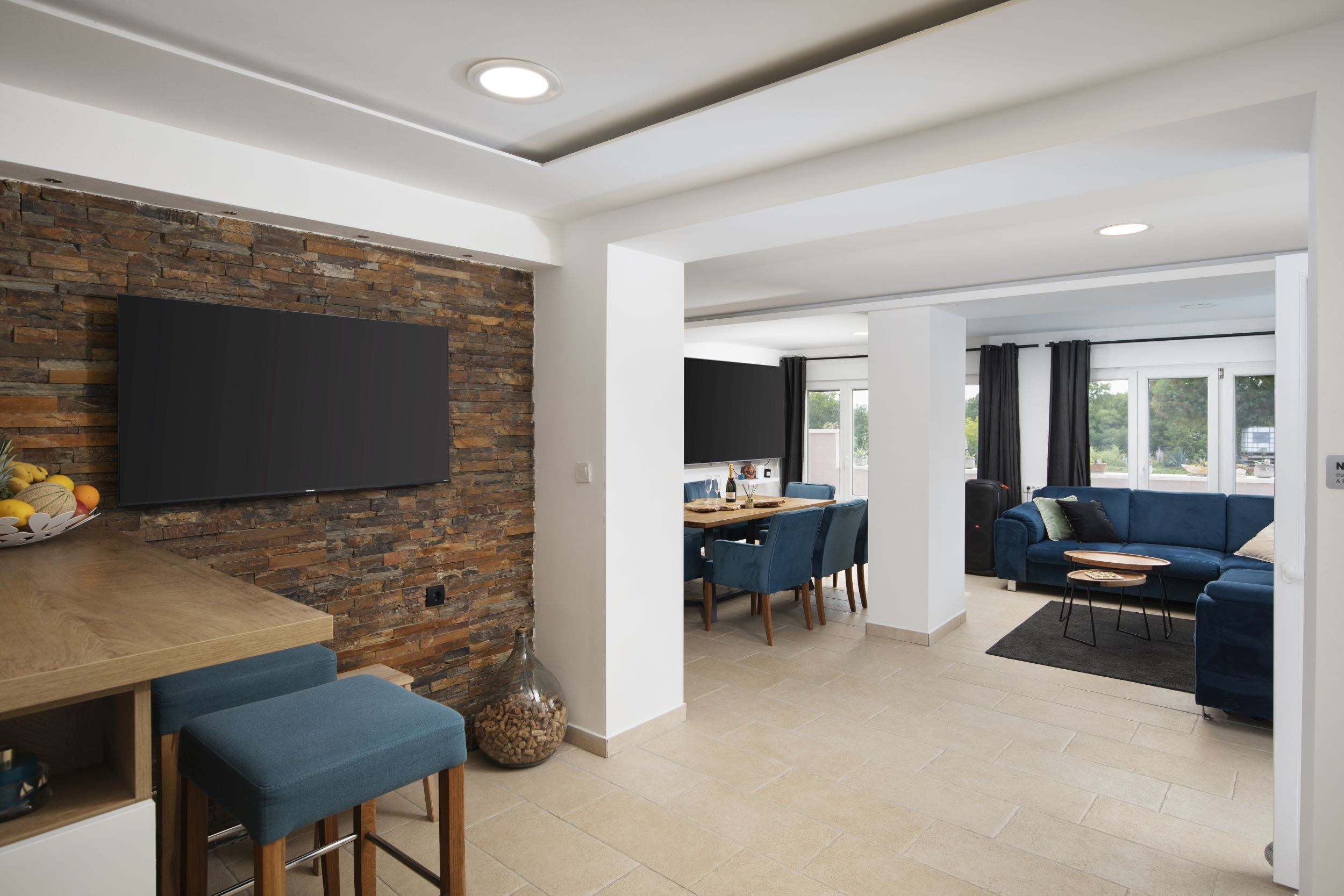A modern living space with a kitchen area, dining table, and seating area.