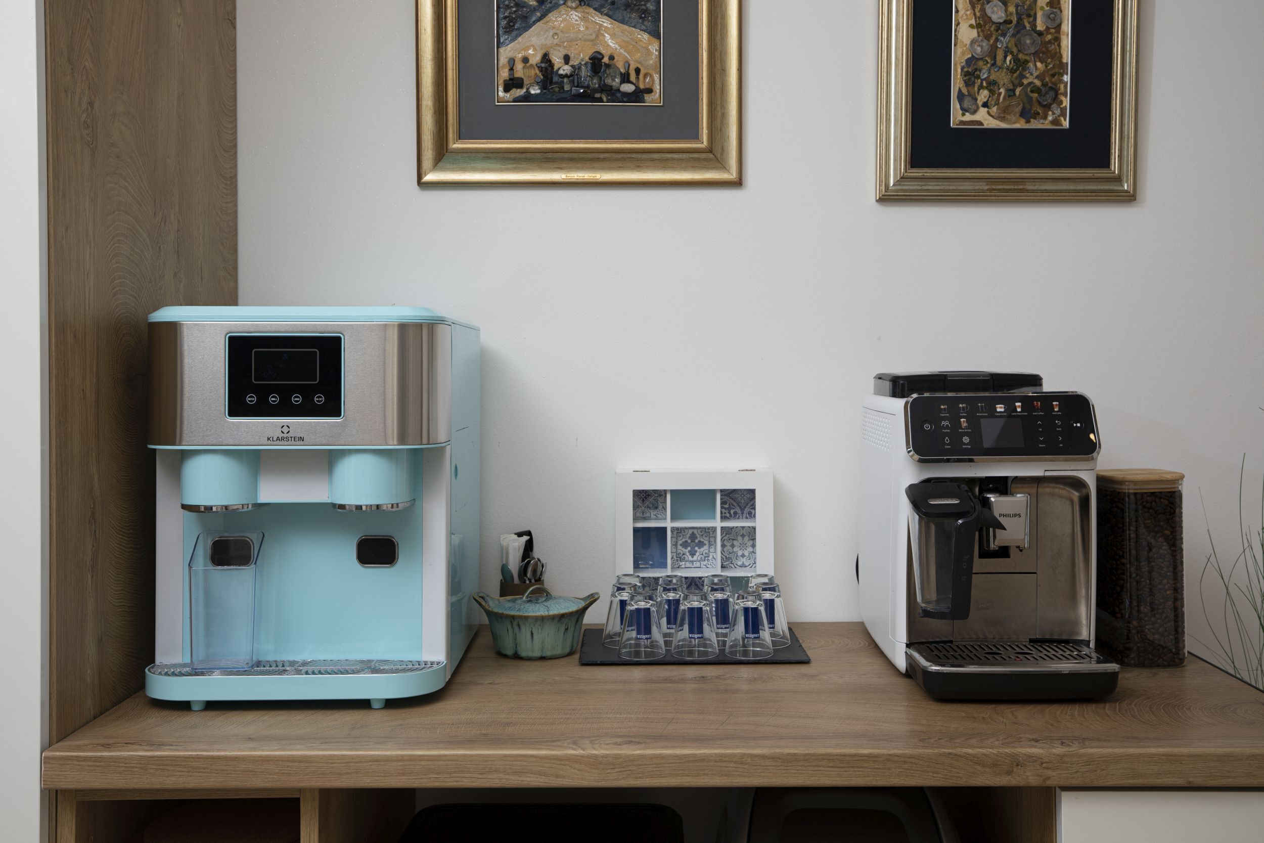 Eine Küchenzeile mit einer Kaffeemaschine, einem Teezubereiter und einem Wasserspender.