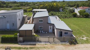 A residential building with a covered patio, a staircase, and a fenced yard. - Casa Crystal Istria (Peroj)