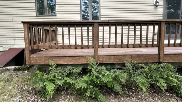 A wooden deck with a railing in front of a house with two windows and a door. - Peaceful 4-bedroom house in charming Castine perfect for relaxing stays (Castine)
