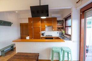 A kitchen with wooden cabinets, a built-in stove, a sink, and a window. - Terrace Lovely Apartment (Roma)