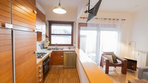 Uma cozinha moderna com armários de madeira, máquina de lavar louça embutida e uma janela grande.