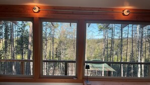 A room with large windows, wooden beams, and a view of a forest. - Glamping tower north of Columbia Falls views of Whitefish mountain and privacy. (Columbia Falls)
