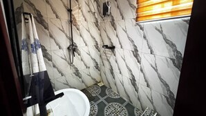 A bathroom with a shower, a sink, and a toilet.