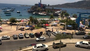 A coastal town with a beach, parked cars, and boats in the water. - Beachfront Apartment : Caleta Beach + Free Parking (Acapulco de Juárez)