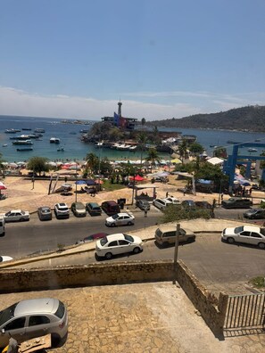 A coastal town with a beach, parked cars, and boats in the water. - Beachfront Apartment : Caleta Beach + Free Parking (Acapulco de Juárez)