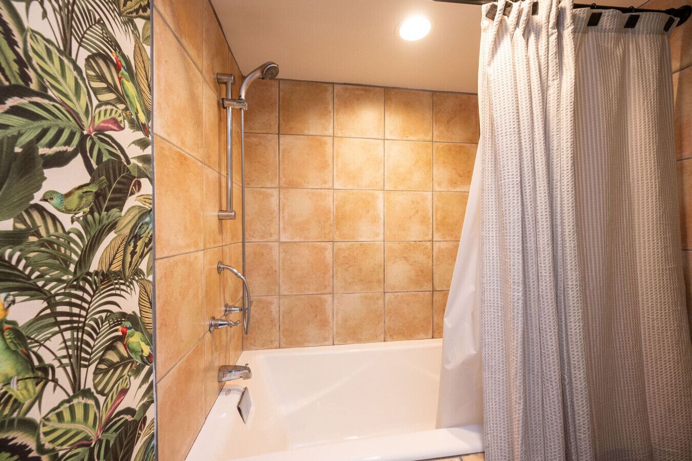 A bathroom with a bathtub, shower, and a curtain.