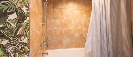 A bathroom with a bathtub, shower, and a curtain.