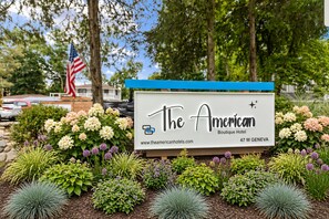 Une enseigne pour l’hôtel The American Boutique Hotel, avec l’adresse de son site web et son adresse postale.