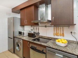 Eine moderne Küche mit Edelstahlgeräten, Holzschränken und einer Arbeitsplatte aus Granit.