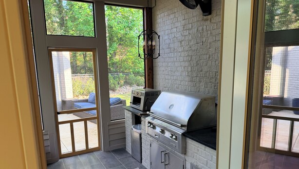 A kitchen with a grill, a fan, and a view of the outdoors. - Grand Oaks 6BR by Country Club - Sleeps 12 + Crib - Sauna, Pizza Oven, Ole Miss (Oxford)