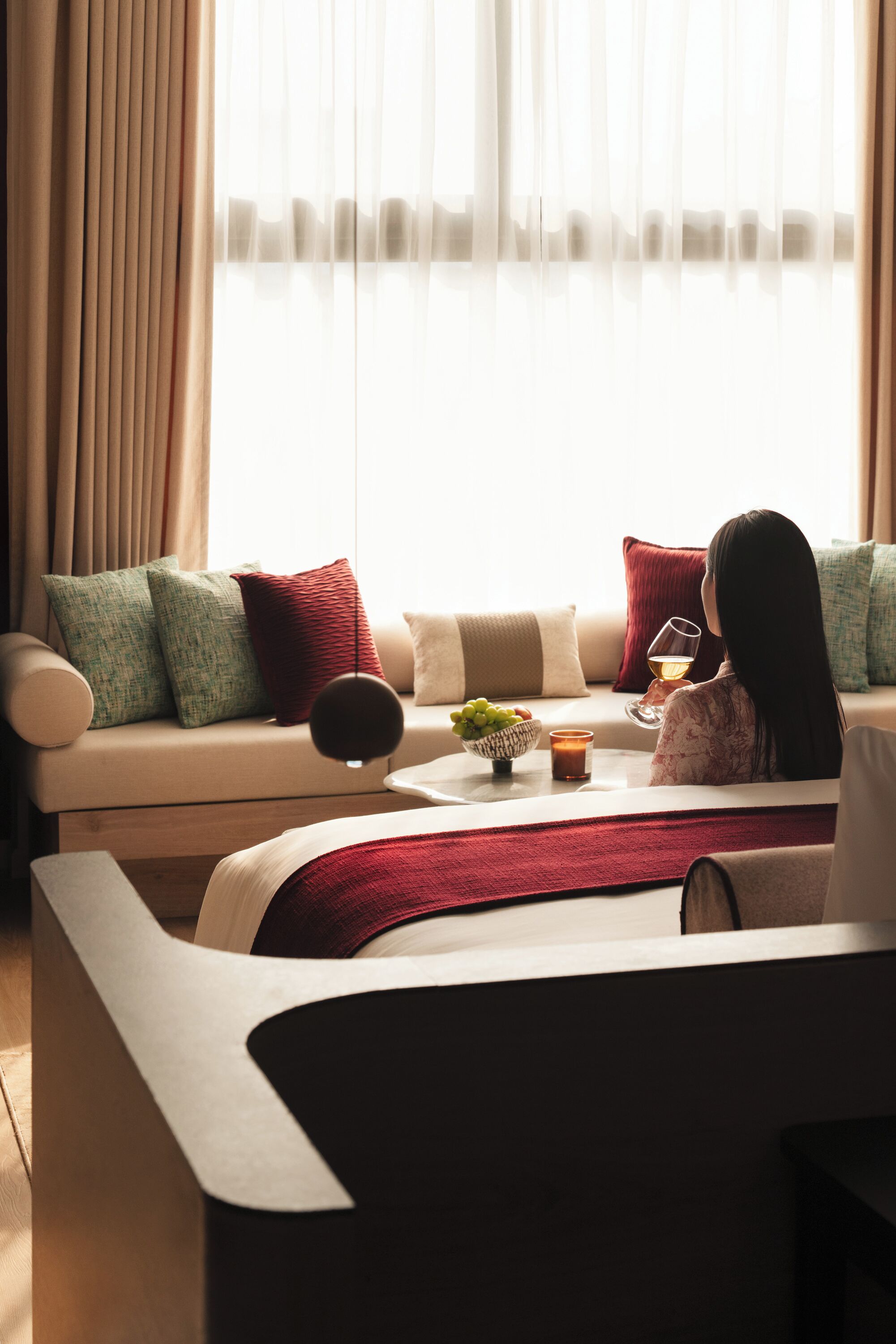 Ein modernes Wohnzimmer mit einer Couch, einem Couchtisch und einer Person, die ein Glas hält.