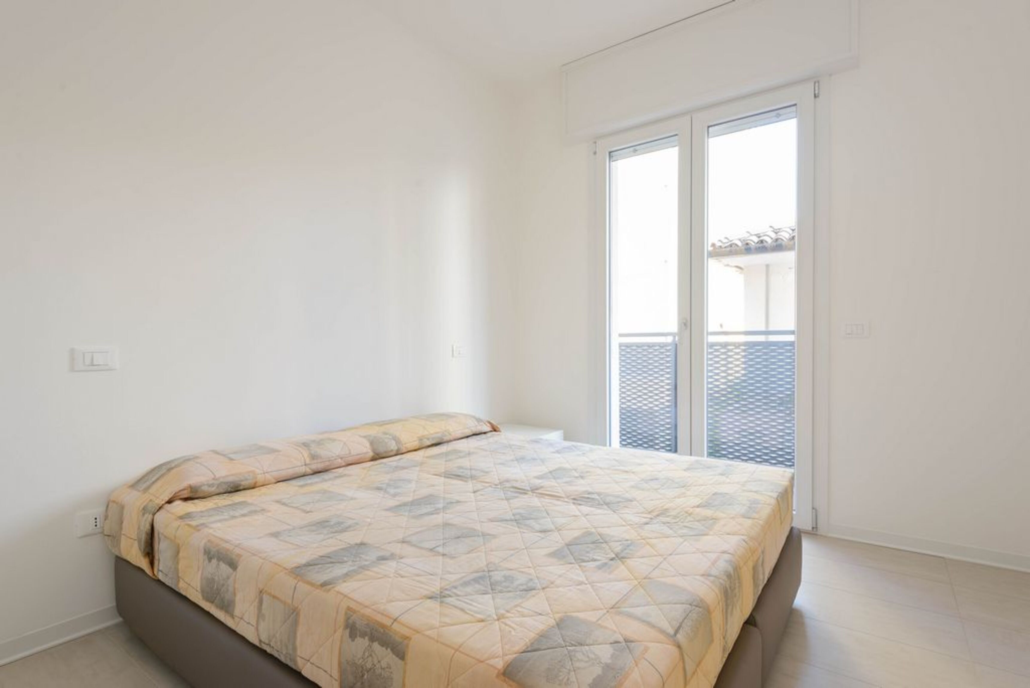 Une chambre à coucher avec un lit, une fenêtre et une porte.