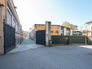 A gated alleyway with buildings on either side, a clear sky, and a no parking sign. - Domus Talenti by Interhome (Alba)