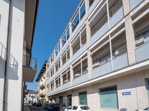 Ein mehrstöckiges Gebäude mit Balkonen, einem Parkplatz und einem blauen Hinweisschild.