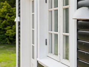 Ein Gebäude mit weißen Außenwänden und einem Fenster mit weißem Rahmen.