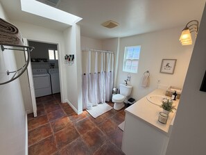 Un baño con inodoro, lavamanos y cortina de ducha.