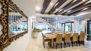 A modern dining area with a large wooden table, wicker chairs, and a decorative mirror. - Huge Private Pool Villa Atala Canggu Seminyak 4BR (Kerobokan)