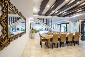 A modern dining area with a large wooden table, wicker chairs, and a decorative mirror. - Huge Private Pool Villa Atala Canggu Seminyak 4BR (Kerobokan)