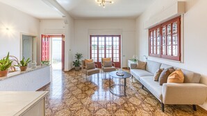 A spacious living area with a sofa, chairs, a coffee table, and a large window with a view.