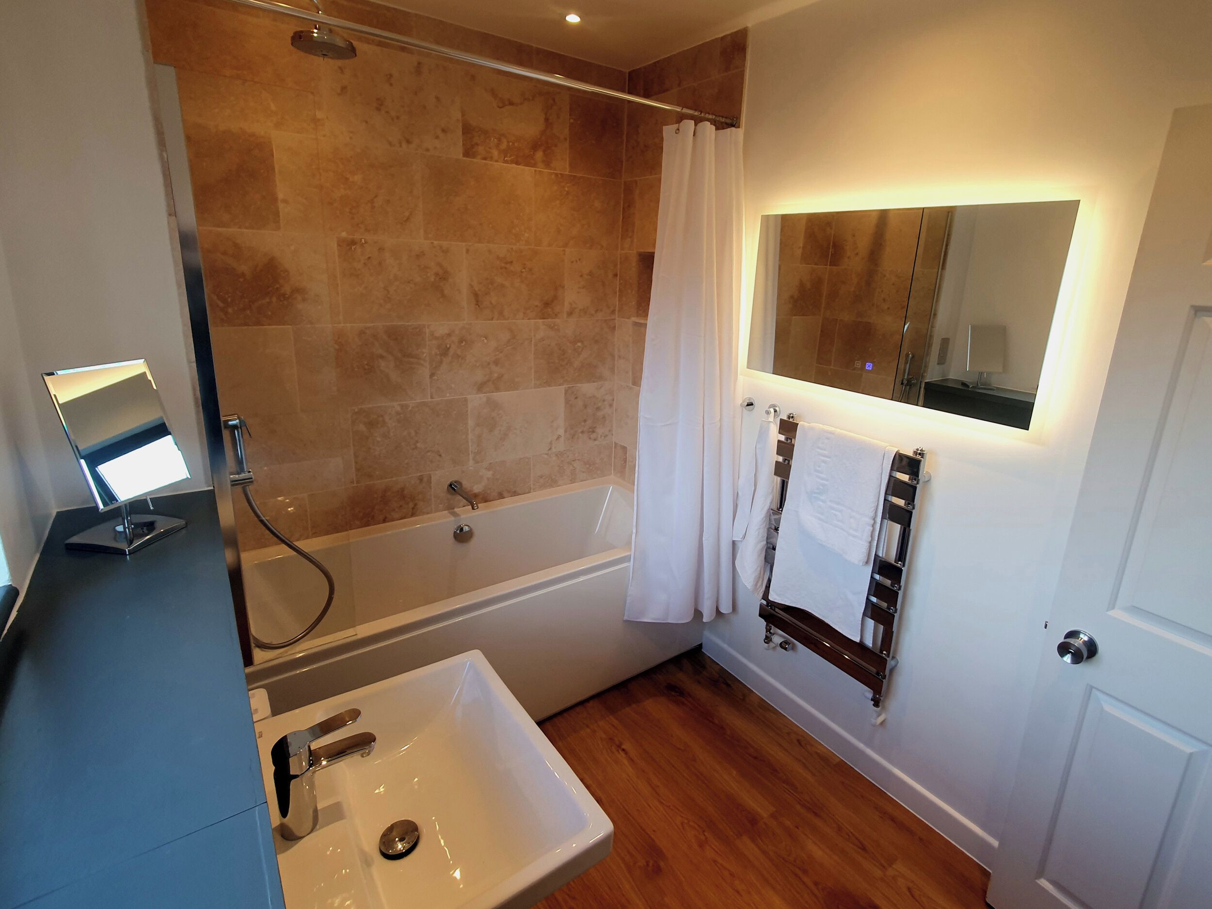 A bathroom with a bathtub, a sink, a mirror, and a shower curtain.