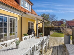 A patio with a table and chairs, a barbecue grill, and a wooden deck. - "Etje" - 650m from the sea by Interhome (Skagen)