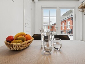 A dining table with a fruit basket, a pitcher, and two glasses. - "Hinrich" - 4.5km from the sea by Interhome (Aakirkeby)