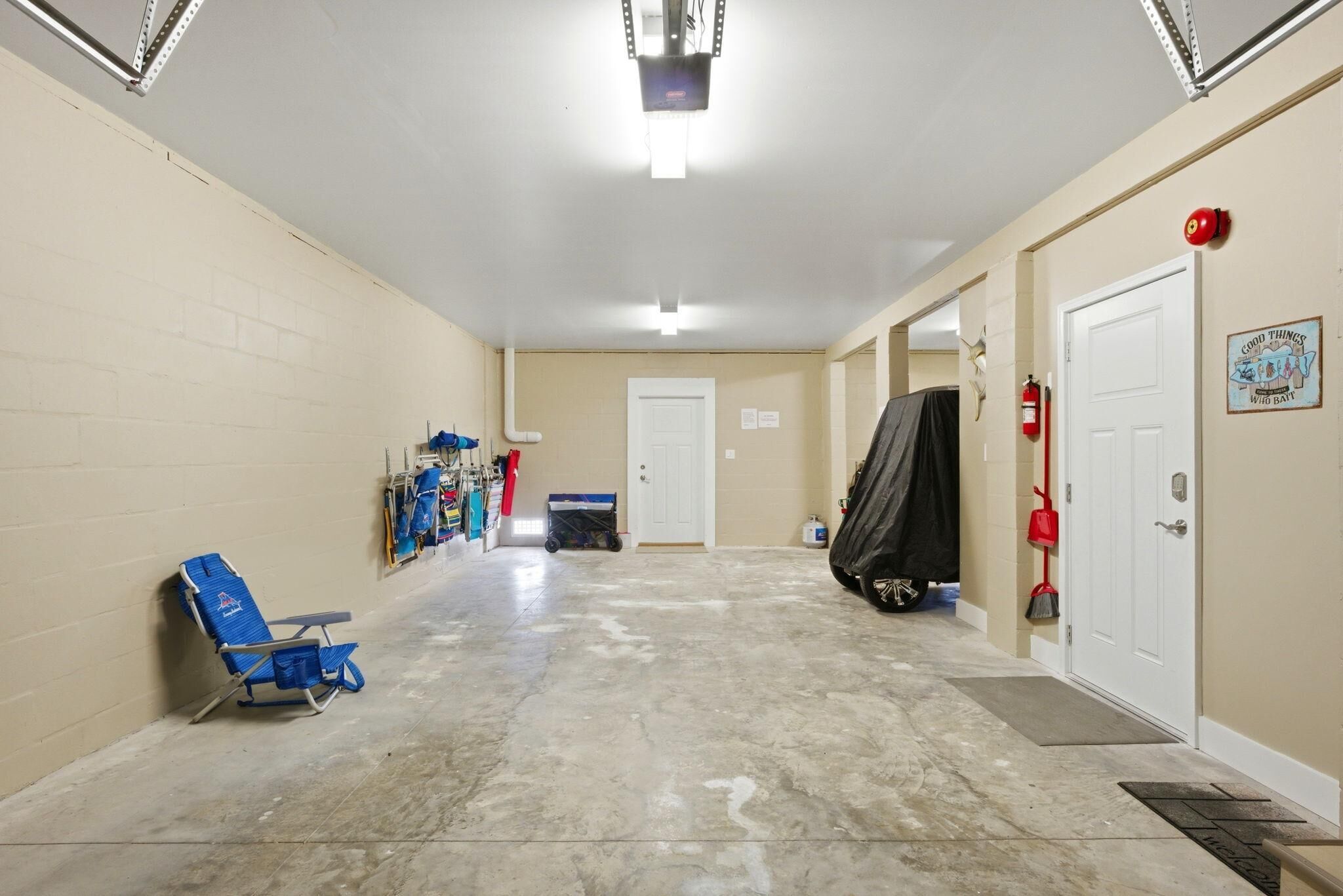 A clean, well-lit hallway with a blue chair, a door, and a coat rack.