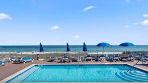 A pool area with lounge chairs and umbrellas, overlooking the ocean. - Sandy Feet Retreat at Lost Key Villas (Pensacola)