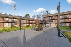 A multi-story brick building with a covered outdoor patio area. - Private Studio Near Everything | NC (Charlotte)