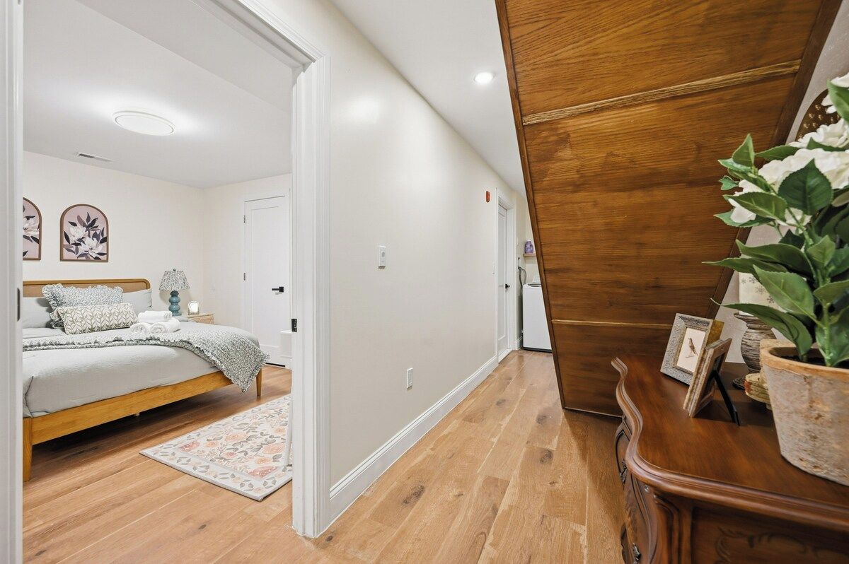 A bedroom with a wooden bed, a nightstand, and a bedside table.