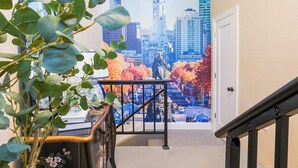Een trap met een leuning, een deur en een muur met een stadsgezichtsmural.