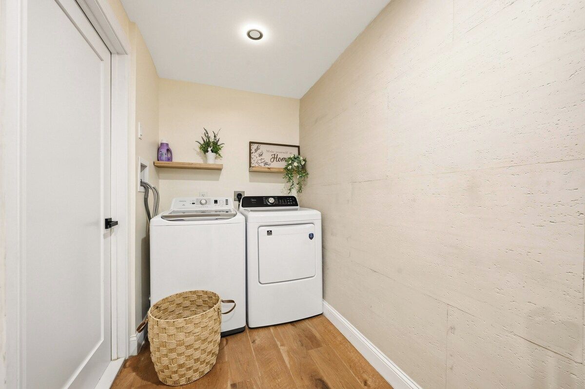 A laundry room with a washing machine, dryer, and a basket.