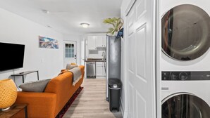 Un appartement moderne comprenant un salon, une cuisine et un espace buanderie.