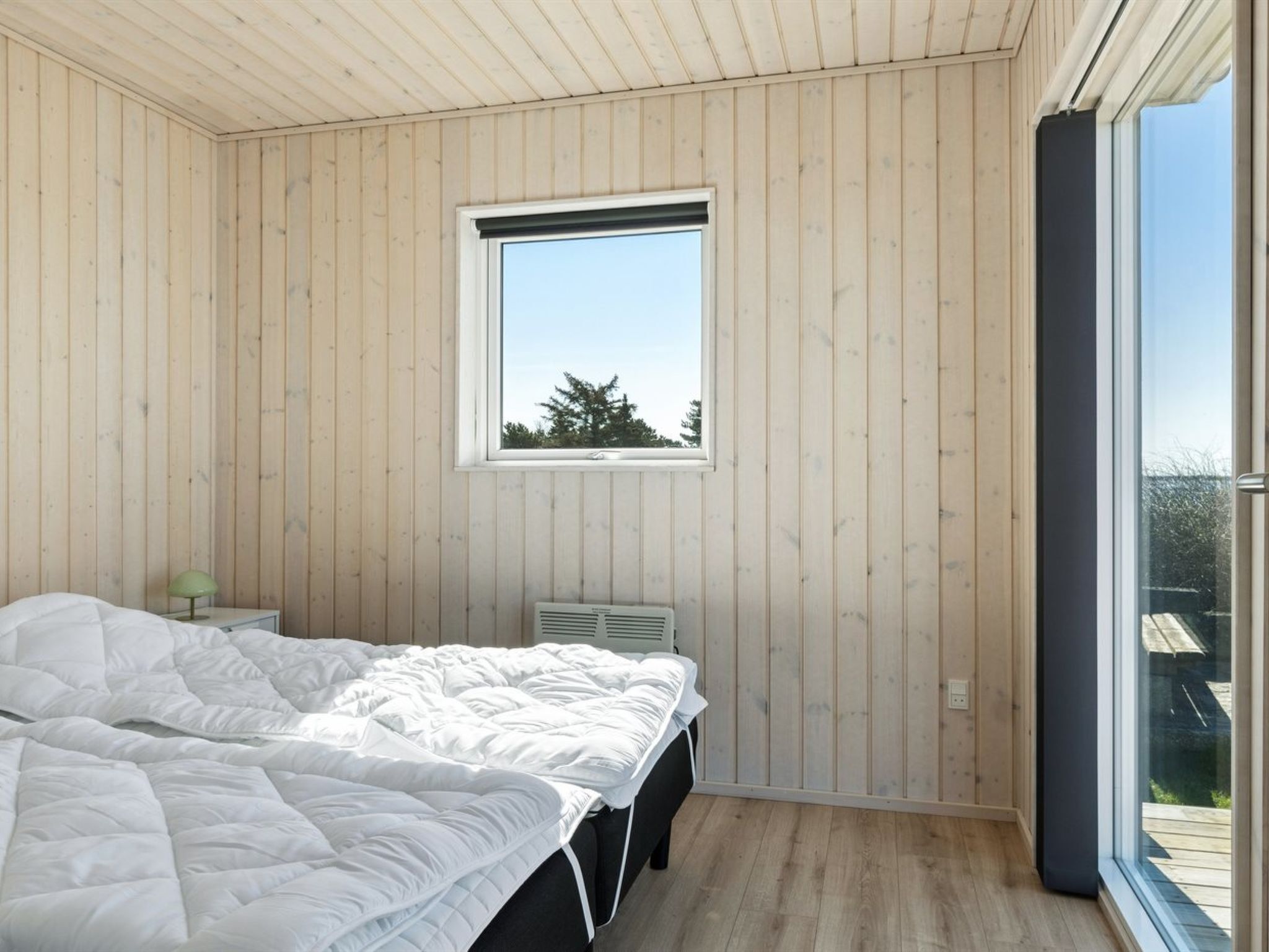 Une chambre à coucher avec un lit, une fenêtre et un radiateur.