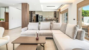 Un saló modern amb un sofà modular, una taula de centre i una cuina al fons.